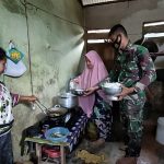 Anggota Satgas TMMD Bantu Warga Siapkan Makan Siang